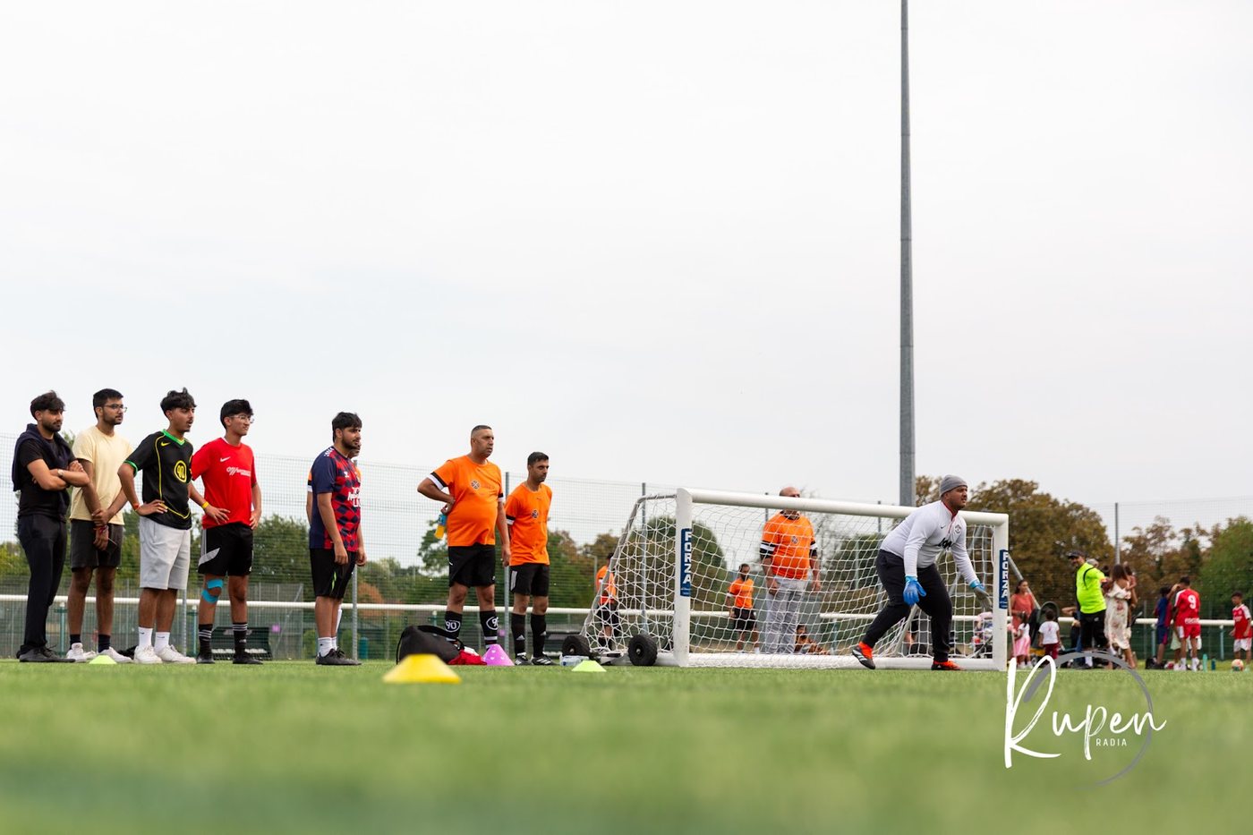 Players watching from behind the goal on the 3G football pitch
