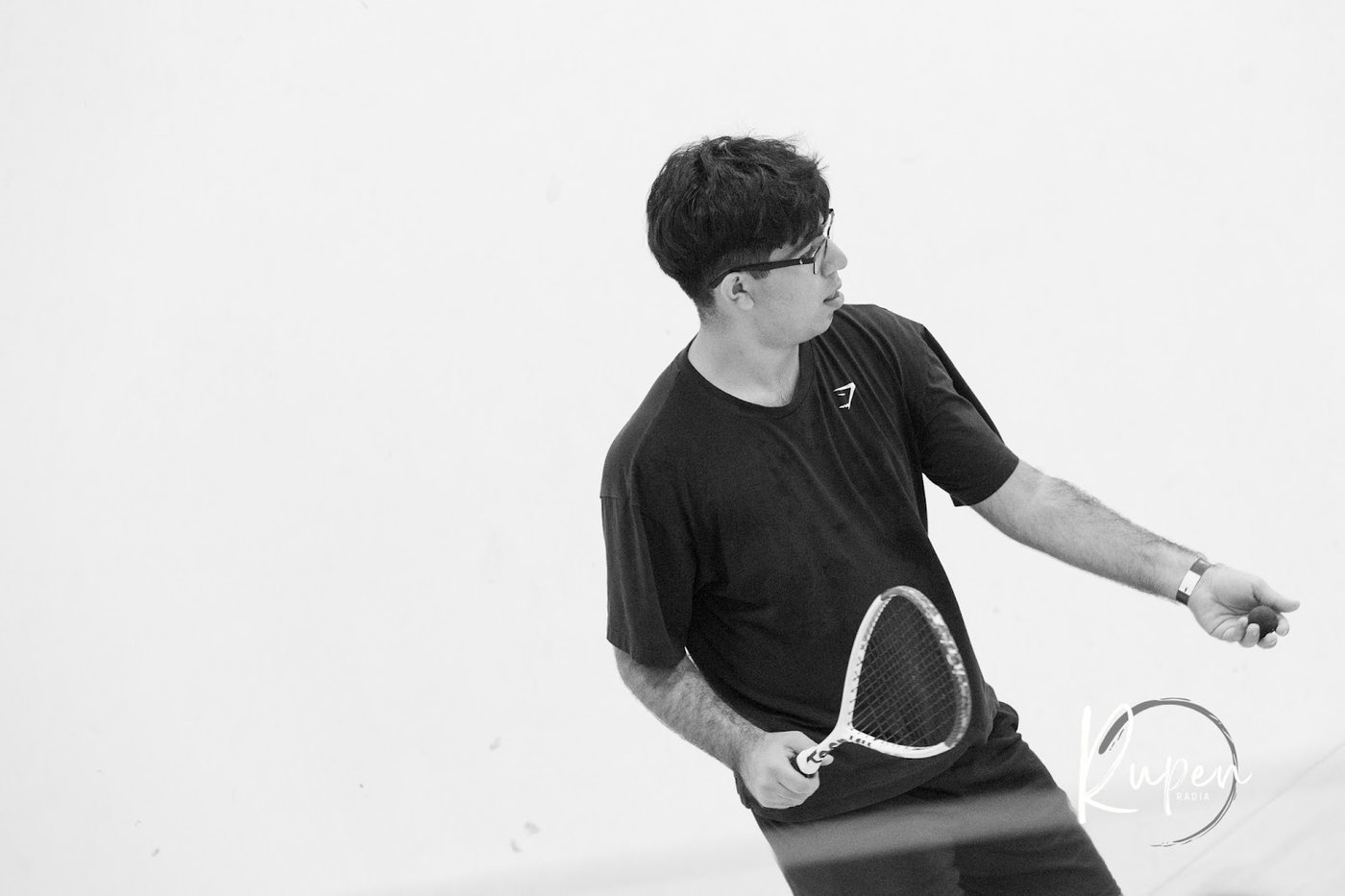 A squash player watching the ball, racket ready