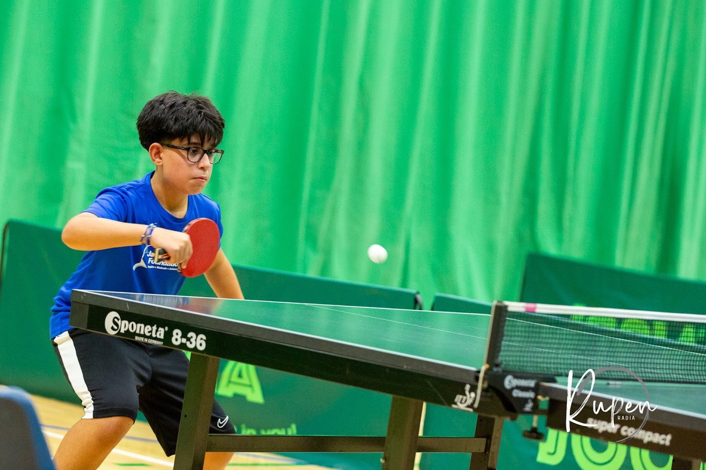 A junior player returning a shot at the table tennis table