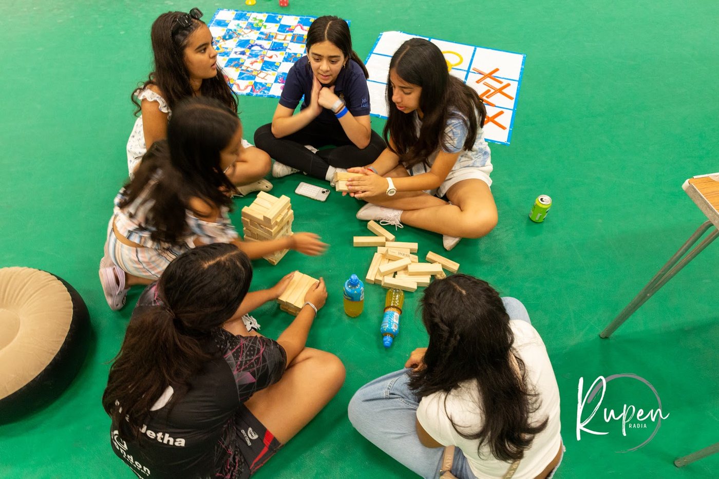 Children playing Jenga and board games together on the floor