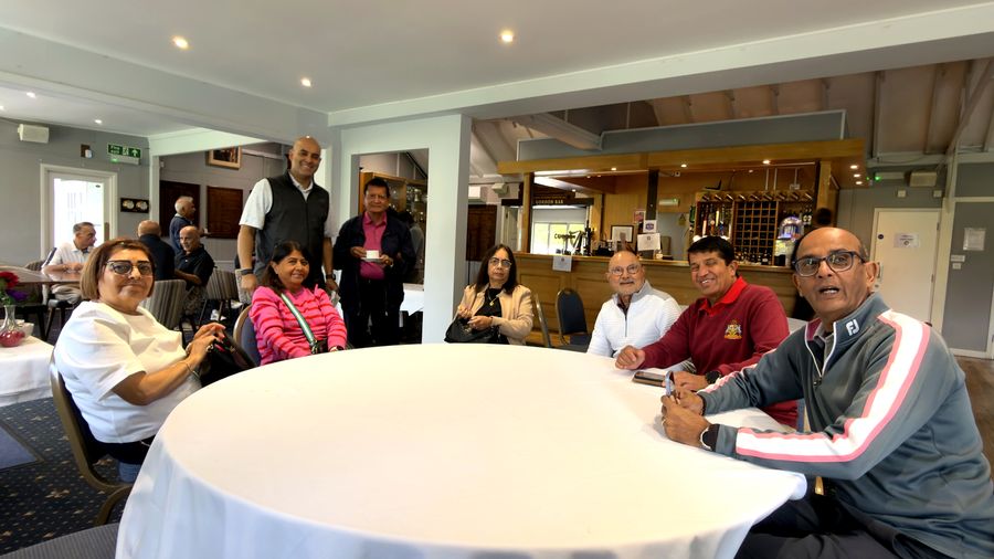 Members of the Lohana community sitting around a round table in the clubhouse before the golf
