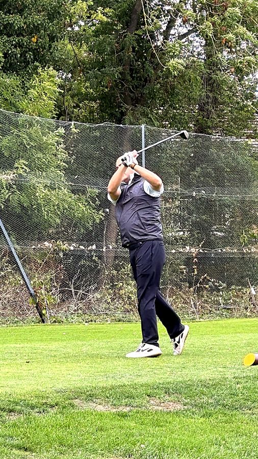 A golfer at the top of his backswing on the first tee at Stanmore Golf Club