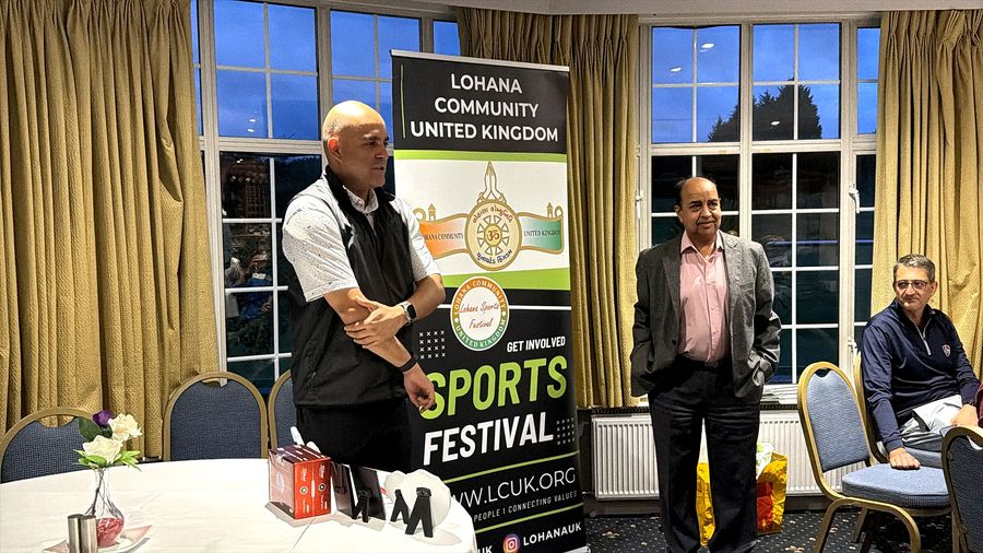The organiser announcing the Golf Day winners beside the Lohana Sports Festival banner in the clubhouse