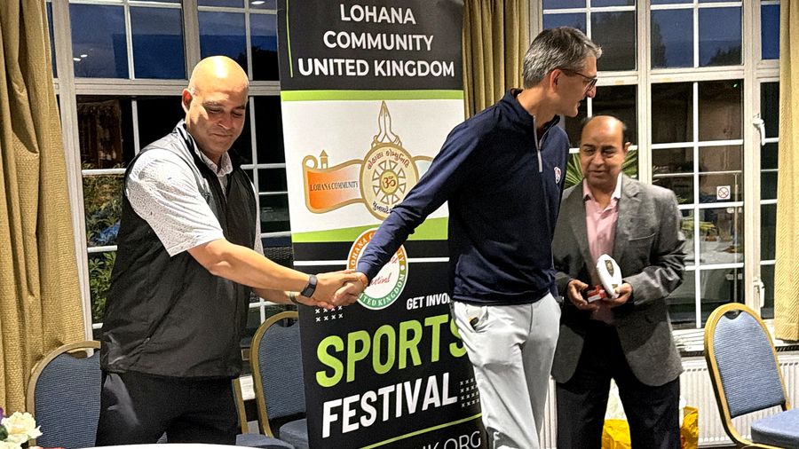The organiser shaking hands with a Golf Day winner as he steps up to collect his trophy