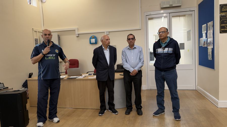 Four men standing together during the players' briefing before the pool tournament begins
