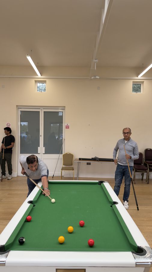 Two pool tables in play at once in the hall at the RCT Centre in Harrow
