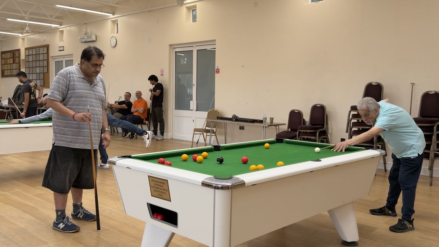Two players either side of a pool table during the doubles competition